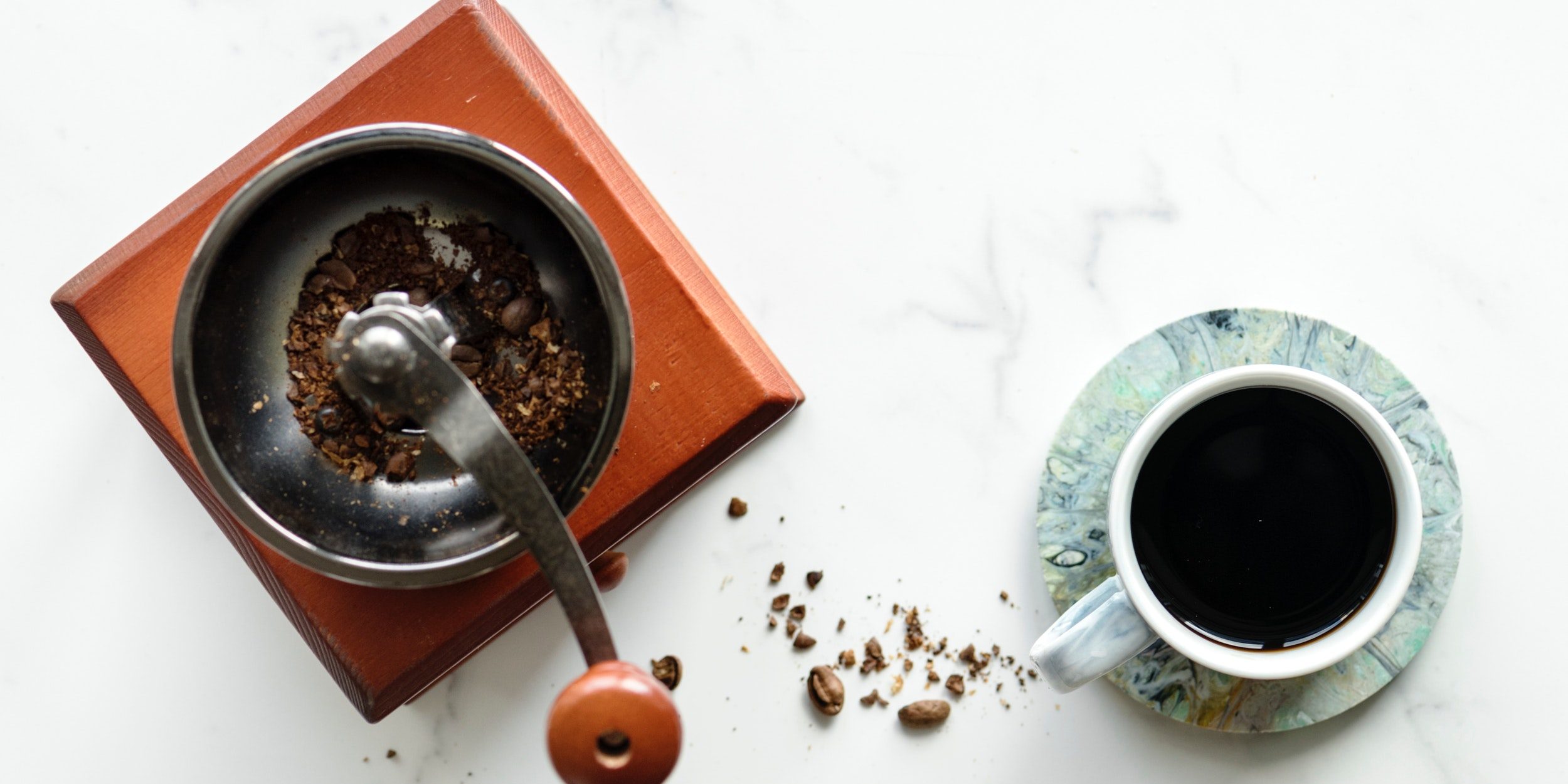 mesada de marmol con taza de café y molinillo de café